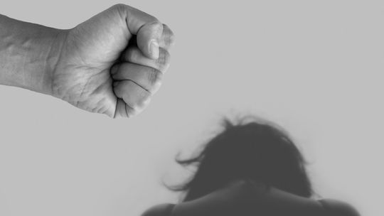 Męska pięść nad głową kobiety