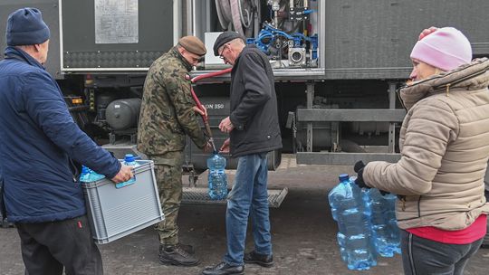 Ludzie biorą wodę z wojskowej cysterny