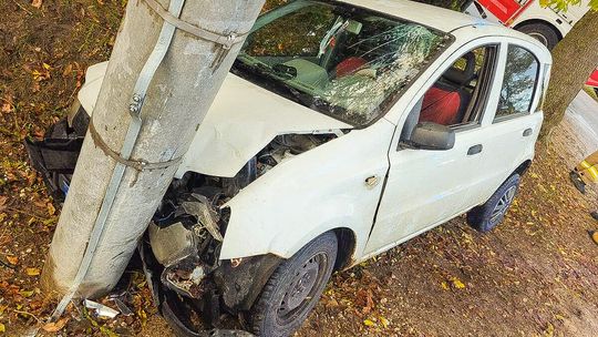 Biały samochód osobowy marki Fiat z rozbitym przodem i pękniętą szybą wbity w betonowy słup oświetleniowy w rowie w miejscowości Gąski pod Ciechanowem