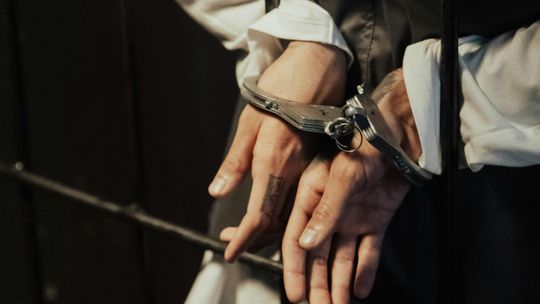Dłonie aresztowanego skute kajdankami