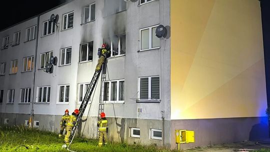 Strażacy przy bloku przy ul. Asnyka w Ciechanowie po pożarze mieszkania