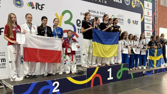 Zawodniczki z medalami na podium Pucharu Świata w Benidorm, polska drużyna z biało-czerwoną flagą na drugim miejscu.