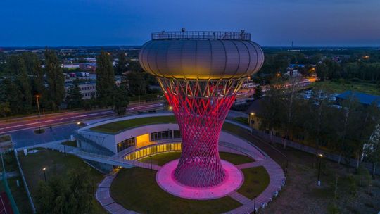 Oświetlona wieża ciśnień w Ciechanowie nocą w Parku Nauki Torus