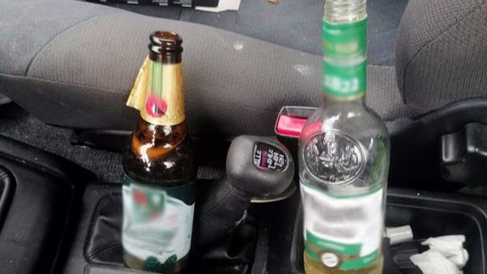 Urządził sobie rajd w pobliżu szkoły. Przy podłokietniku trzymał butelkę wódki i piwo