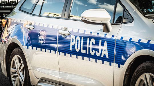 Bok oznakowanego radiowozu policyjnego z widocznym napisem „POLICJA”.