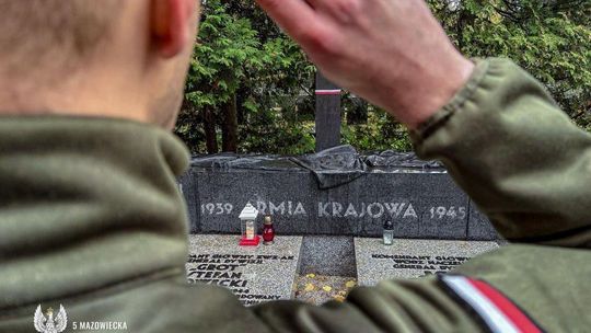 Żołnierz salutuje oddając hołd bohaterom