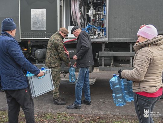 Ludzie biorą wodę z wojskowej cysterny