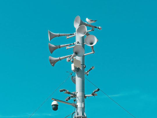 Syrena alarmowa na maszcie na tle nieba - test syren alarmowych w Ciechanowie