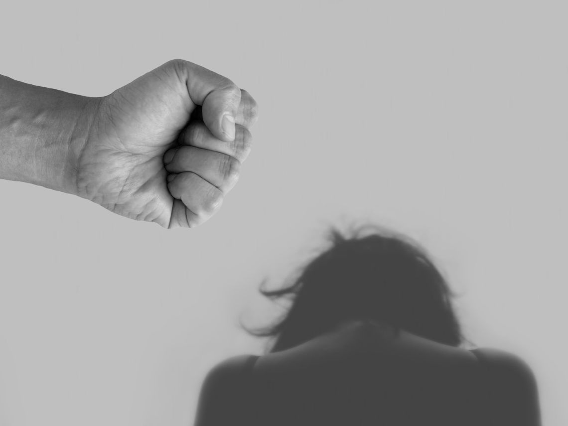 Męska pięść nad głową kobiety