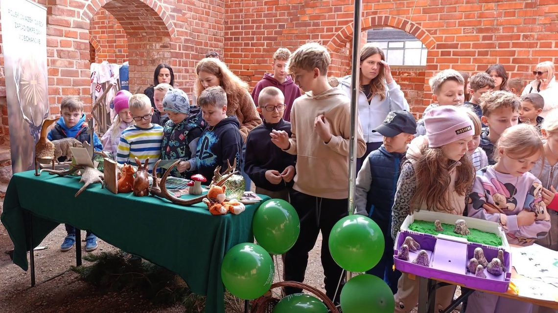 Dzieci przy stoisku edukacyjnym Polskiego Związku Łowieckiego w Ciechanowie podczas wydarzenia Leśna Przygoda.