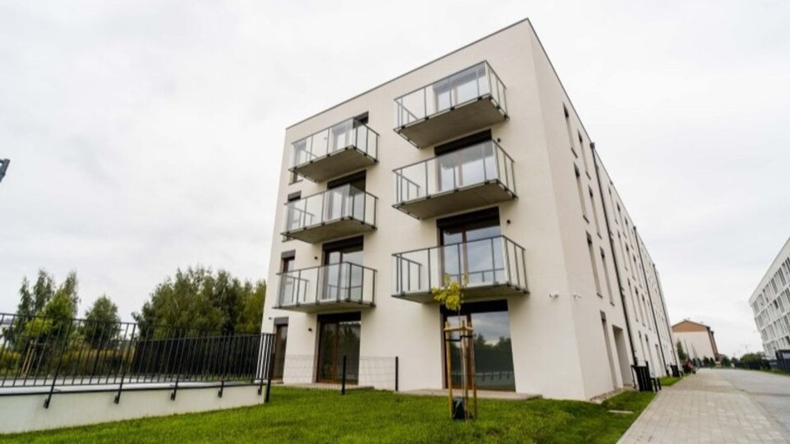 Lokatorzy odebrali klucze do 78 mieszkań przy ulicy Soplińskiego. Ciechanów szykuje kolejny nabór Nowy jasny blok mieszkalny z balkonami ze szklanymi balustradami i chodnikiem w Ciechanowie