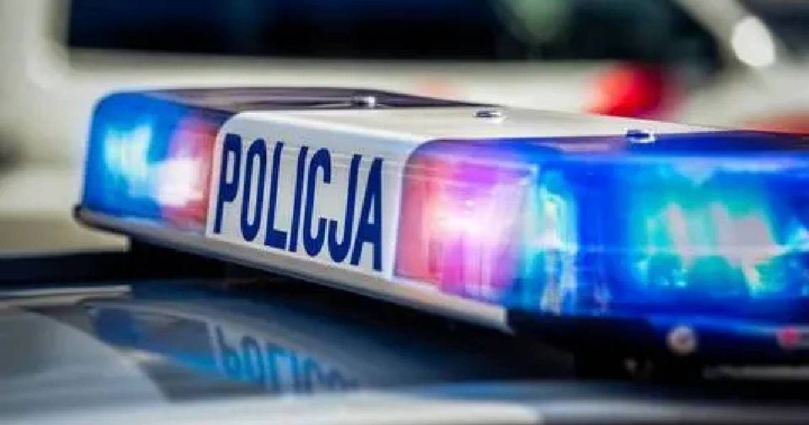 Niebieskie i czerwone światła sygnalizacyjne na dachu radiowozu z napisem Policja.