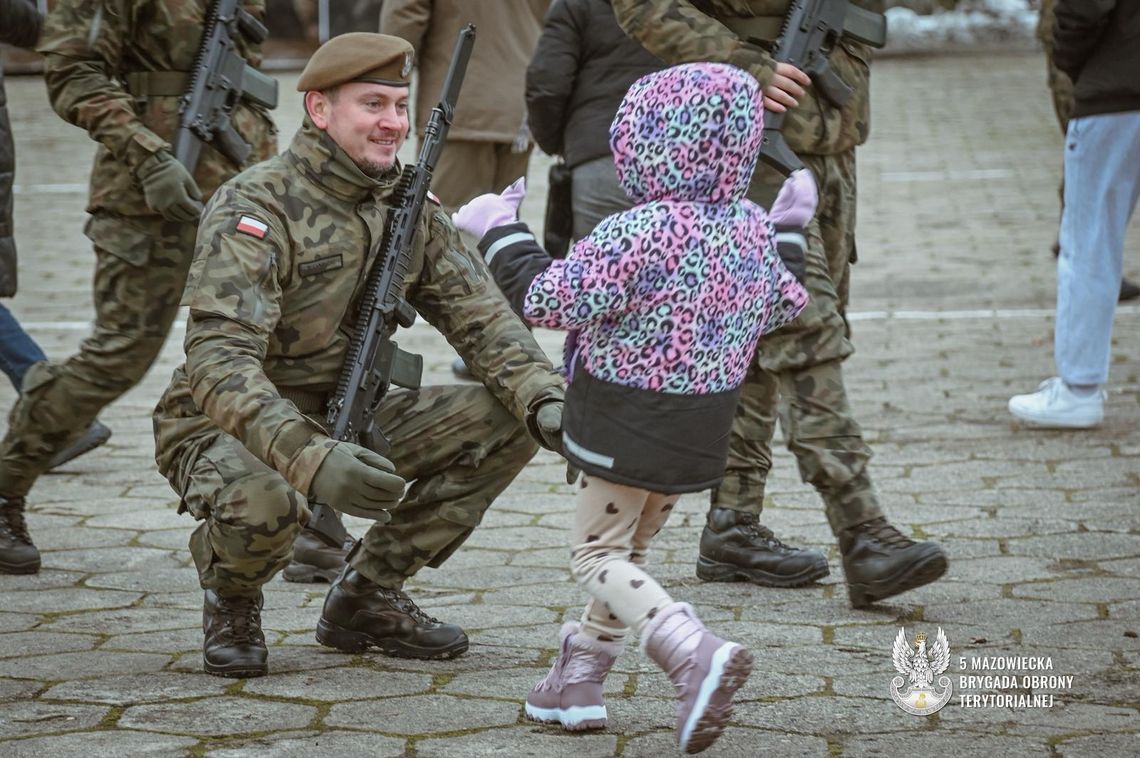Ostatnia przysięga w tym roku i awanse podoficerskie w 5. Mazowieckiej Brygadzie OT w Ciechanowie Żołnierz WOT po jego przysiędze, z dzieckiem