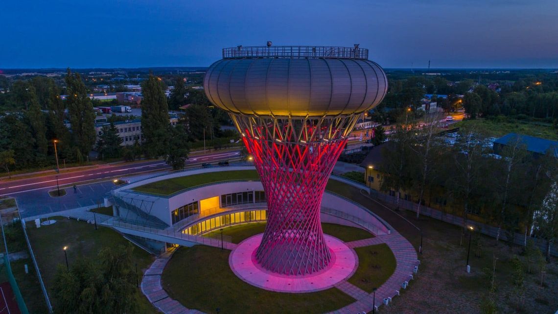 Oświetlona wieża ciśnień w Ciechanowie nocą w Parku Nauki Torus