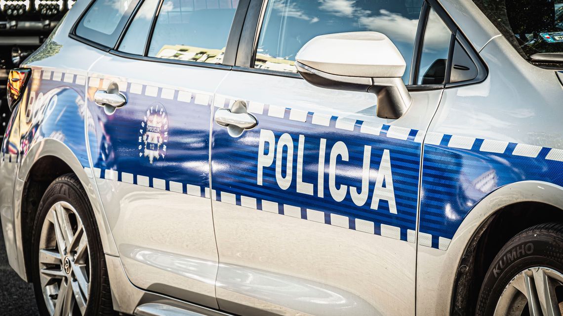 Bok oznakowanego radiowozu policyjnego z widocznym napisem „POLICJA”.