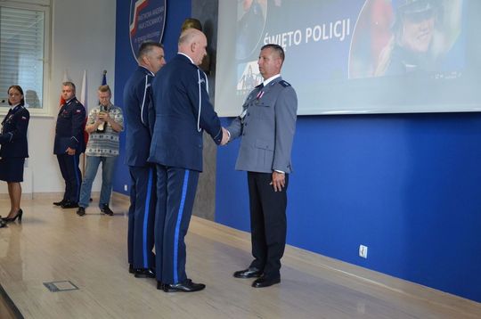 106 lat Policji Państwowej i 100 lat kobiet w służbie. Uroczystości w Mławie Uroczystości Święta Policji w Mławie, w tle wyróżnieni policjanci i goście, obchody 100-lecia kobiet w Policji.