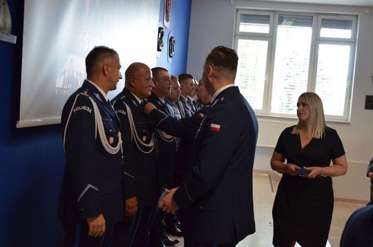 106 lat Policji Państwowej i 100 lat kobiet w służbie. Uroczystości w Mławie Uroczystości Święta Policji w Mławie, w tle wyróżnieni policjanci i goście, obchody 100-lecia kobiet w Policji.