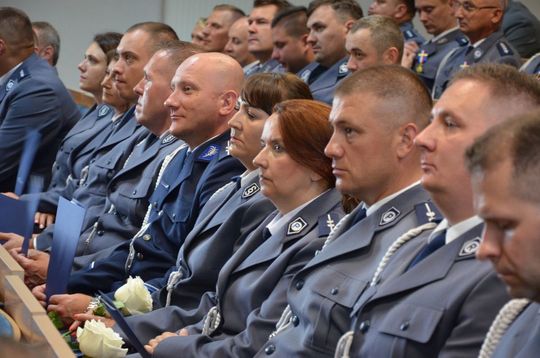 106 lat Policji Państwowej i 100 lat kobiet w służbie. Uroczystości w Mławie Uroczystości Święta Policji w Mławie, w tle wyróżnieni policjanci i goście, obchody 100-lecia kobiet w Policji.