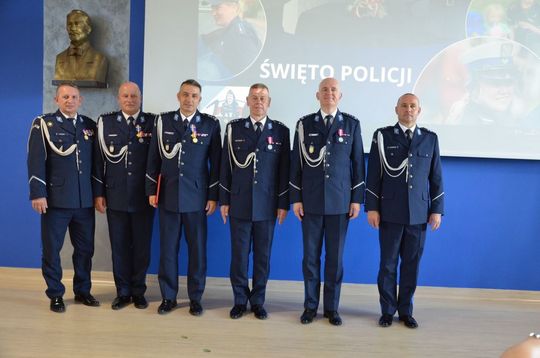 106 lat Policji Państwowej i 100 lat kobiet w służbie. Uroczystości w Mławie Uroczystości Święta Policji w Mławie, w tle wyróżnieni policjanci i goście, obchody 100-lecia kobiet w Policji.