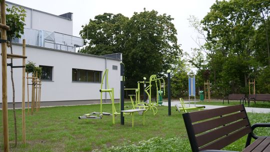 Teren rekreacyjny przy Zespole Szkół nr 4 w Mławie z siłownią zewnętrzną i stołami do gier.