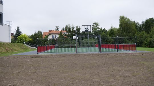 Teren rekreacyjny przy Zespole Szkół nr 4 w Mławie z siłownią zewnętrzną i stołami do gier.