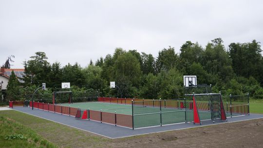 Teren rekreacyjny przy Zespole Szkół nr 4 w Mławie z siłownią zewnętrzną i stołami do gier.
