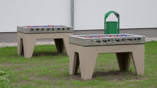 Teren rekreacyjny przy Zespole Szkół nr 4 w Mławie z siłownią zewnętrzną i stołami do gier.