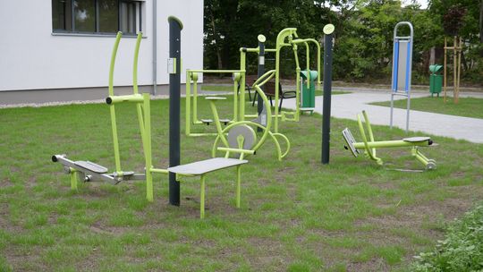 Teren rekreacyjny przy Zespole Szkół nr 4 w Mławie z siłownią zewnętrzną i stołami do gier.