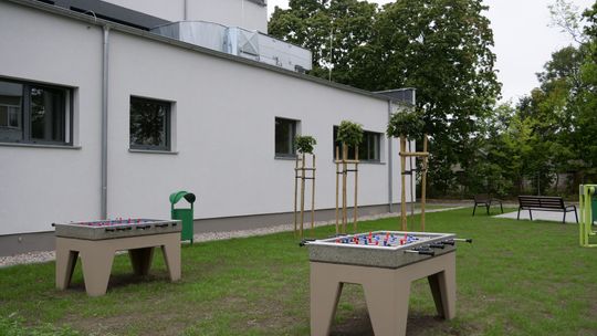 Teren rekreacyjny przy Zespole Szkół nr 4 w Mławie z siłownią zewnętrzną i stołami do gier.