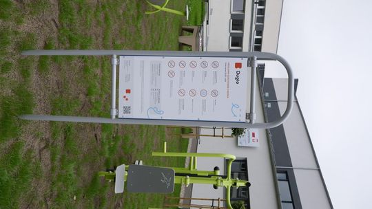 Teren rekreacyjny przy Zespole Szkół nr 4 w Mławie z siłownią zewnętrzną i stołami do gier.