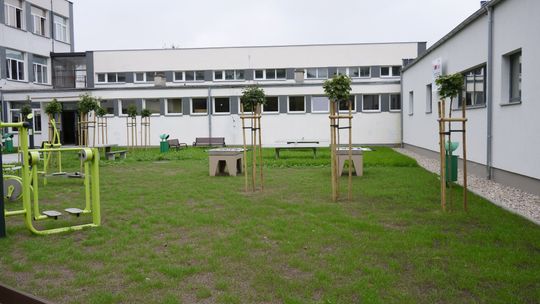 Teren rekreacyjny przy Zespole Szkół nr 4 w Mławie z siłownią zewnętrzną i stołami do gier.